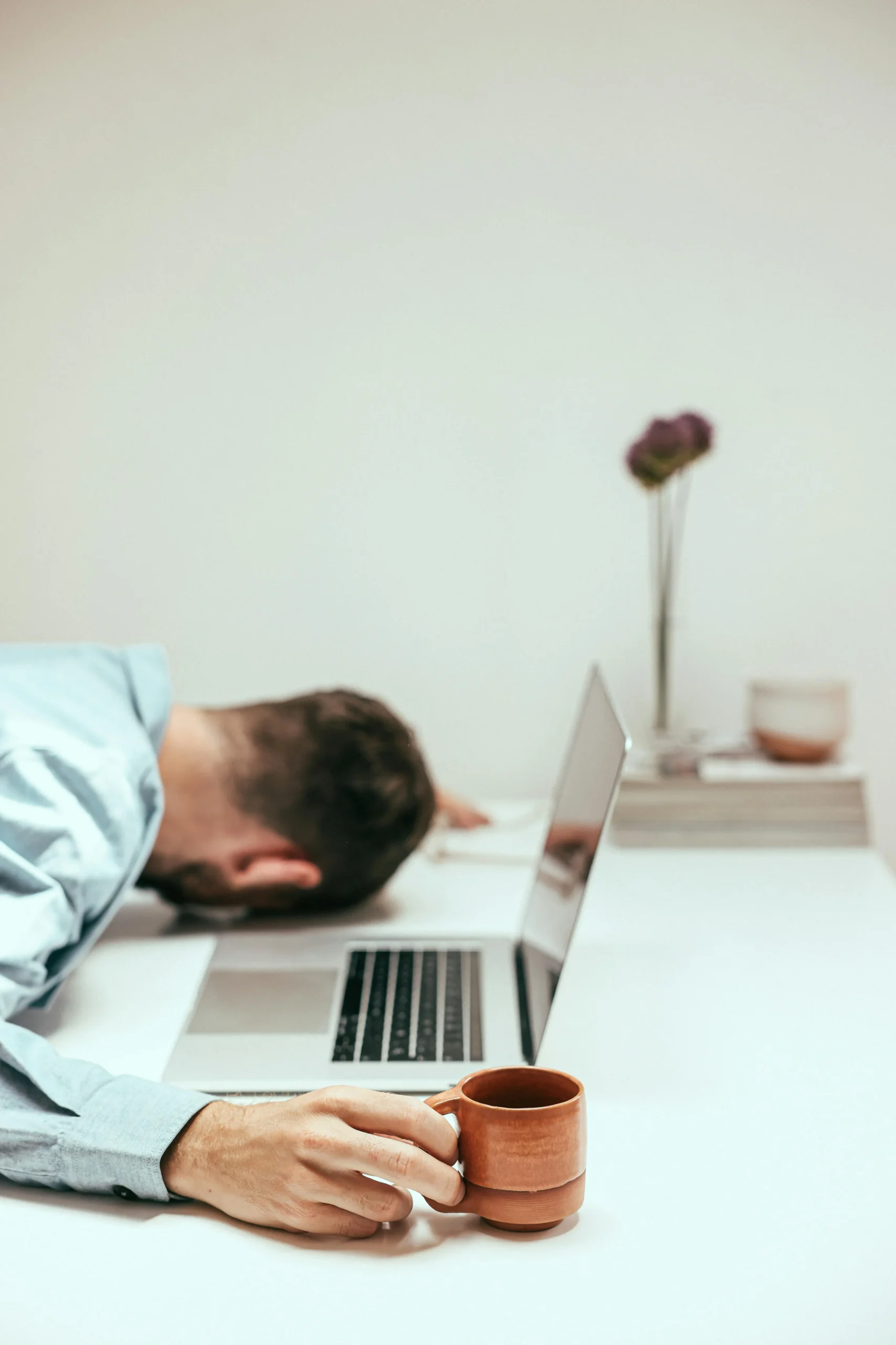 Uitegputte man met zijn gezich op het toetsenbord van zijn laptop