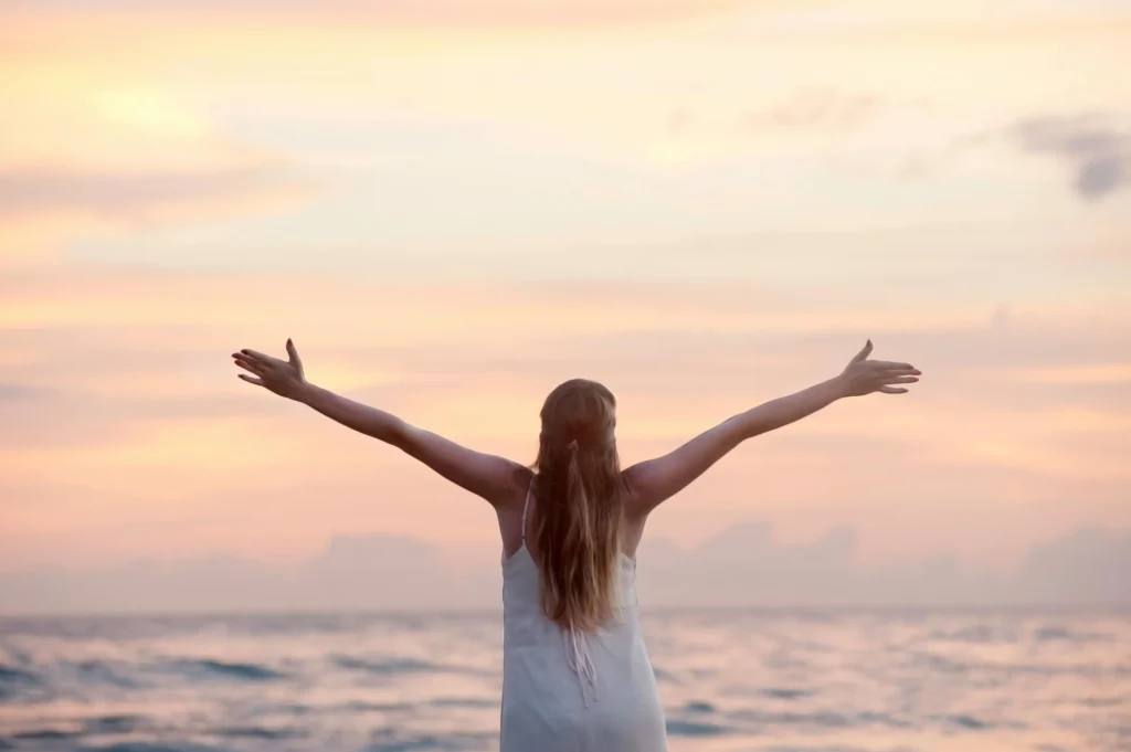 vrouw die geniet van de zonsondergang